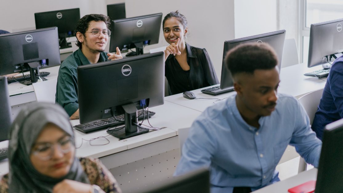 students listening to lecture facing desktops