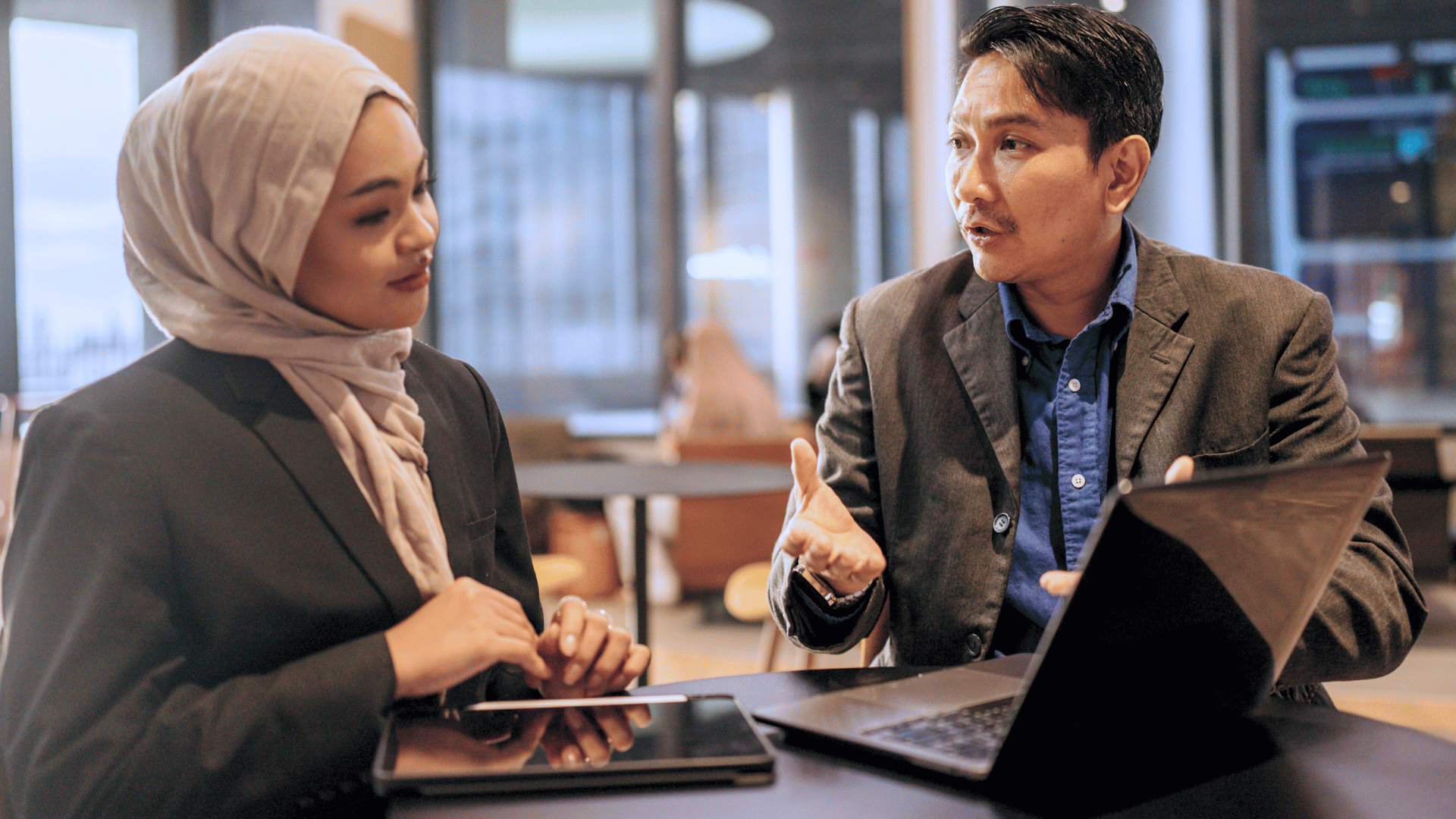 Young female working adult listen intently to her mature co-worker