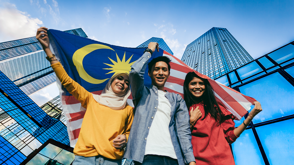 Three young teenagers holding the flag of Malaysia