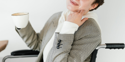 Woman holding a cup on wheelchair