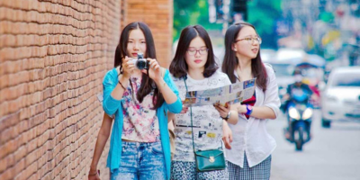 Three young students looking for the attraction of the city