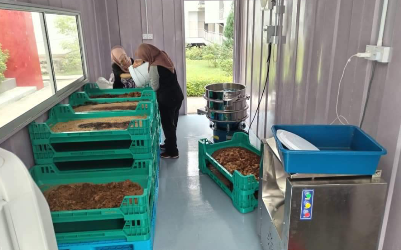 Students working inside the Entomal mobile bioconversion system