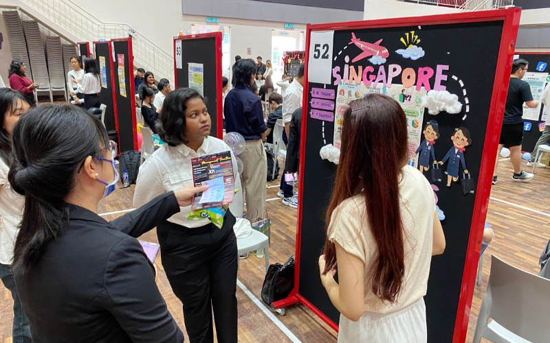 Students presenting to one of the judges, Dr Hue Chi Yin (Left)