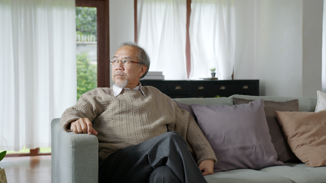 Lonely elder looking at the windows