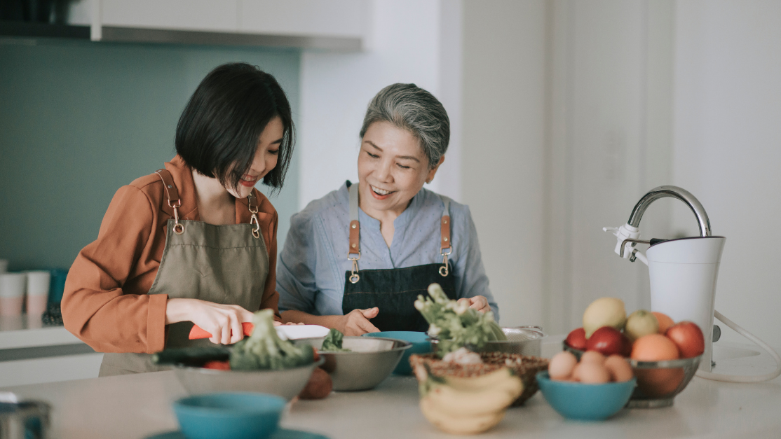 Asian elder cooking together with her daughter