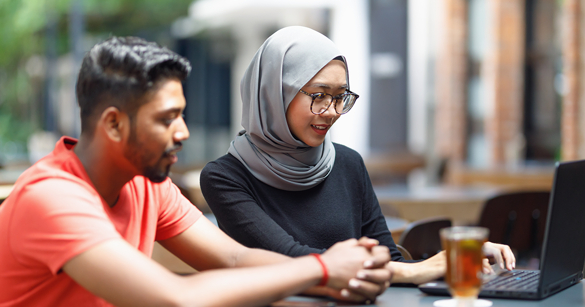 Two students looks at the laptop's screen