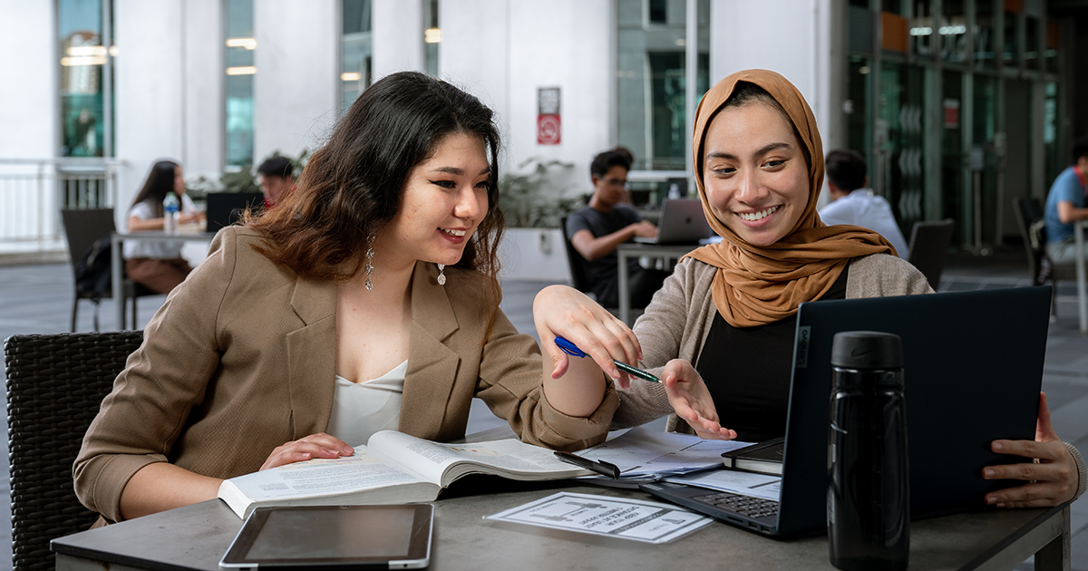 Two students discussing for the project outside library