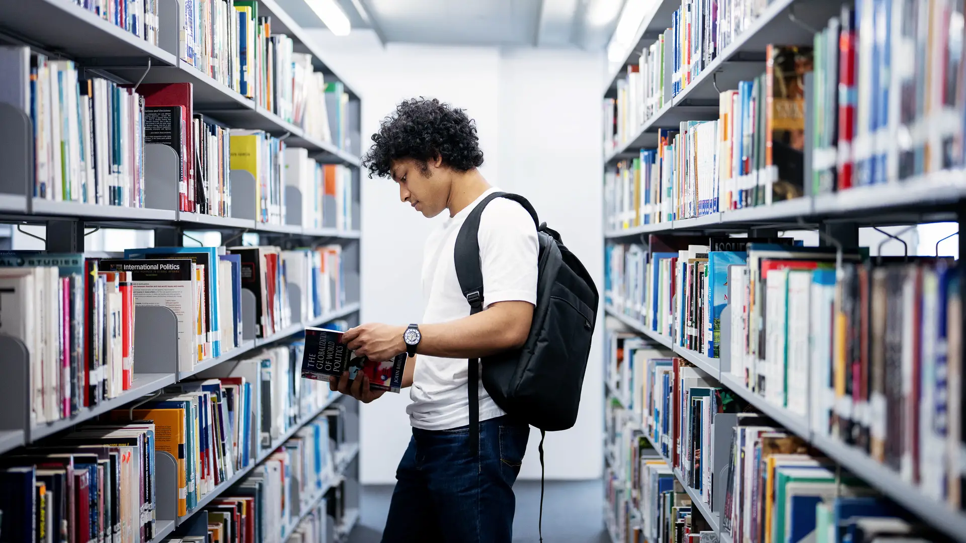 student browsing through books in taylors library