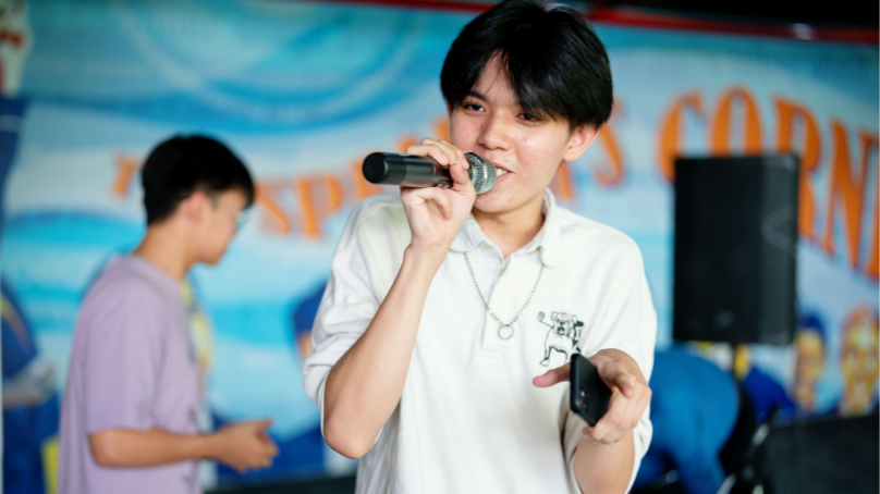 a student giving a speech while holding a phone