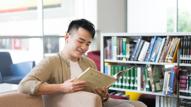 a man reading a book in the library