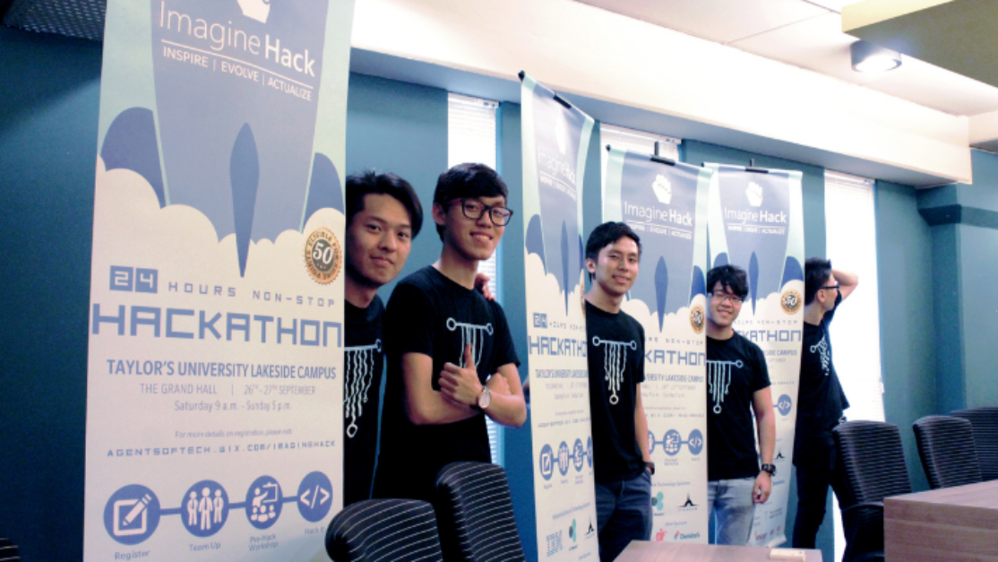 organisers of imagine hack standing beside its event buntings