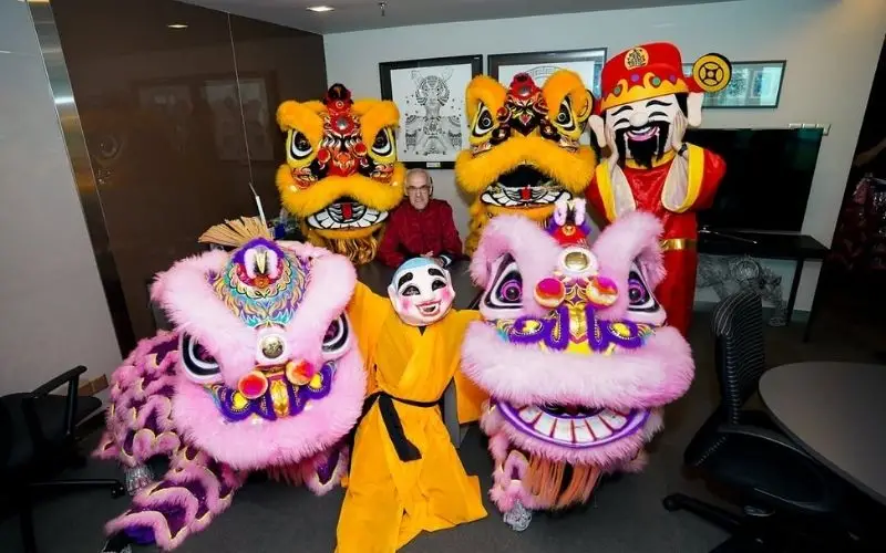lion dance students in costume posing with professor barry 