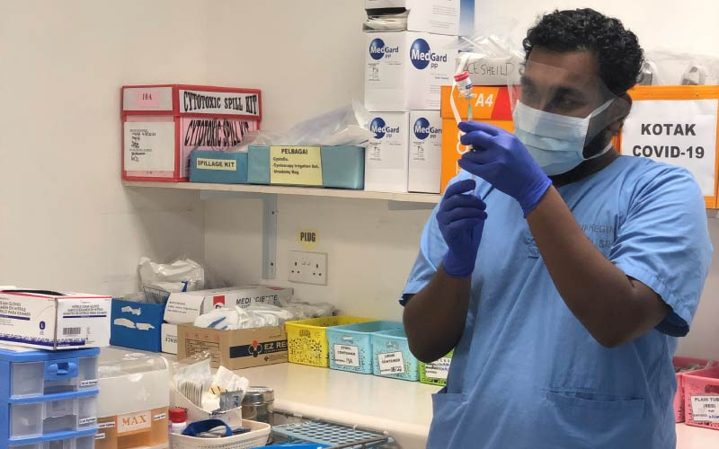 Dr Mahes Arvin preparing a vaccine shot