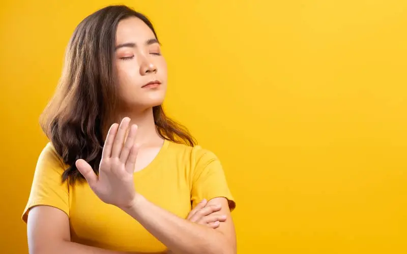 woman in yellow signalling no