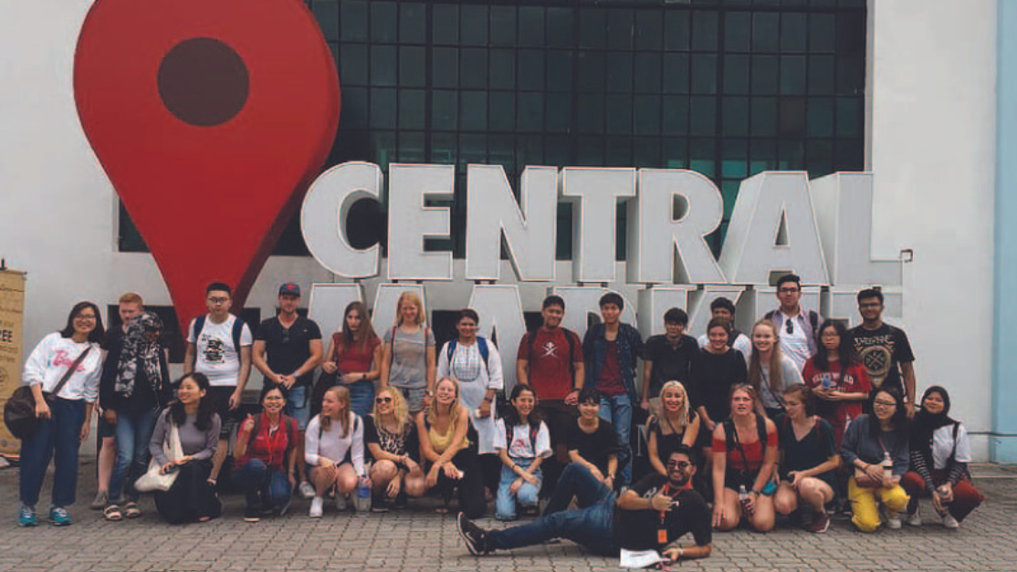 students posing in front of the central market sign