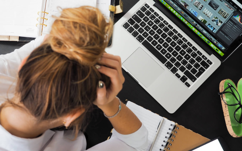 Girl with hands on her head with a laptop