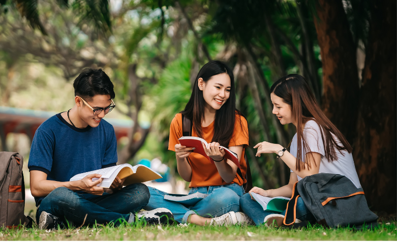 Three friends reading at the park