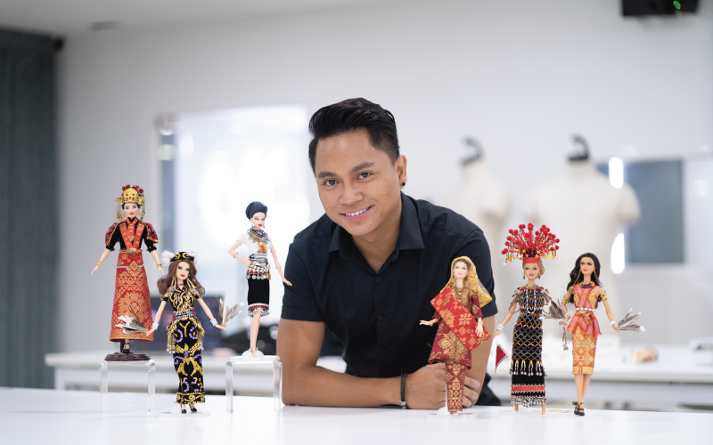 lecturer presents his finished dressed up dolls