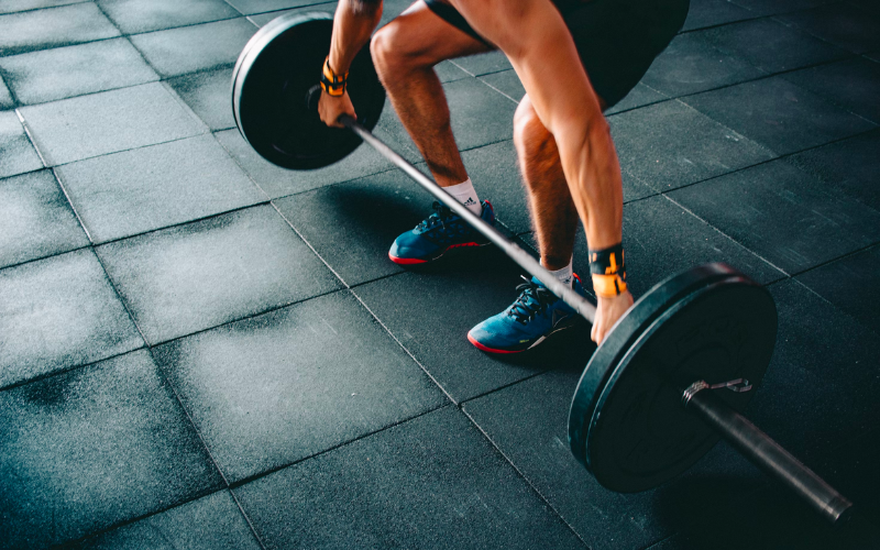 A young guy lifting weight in the gym