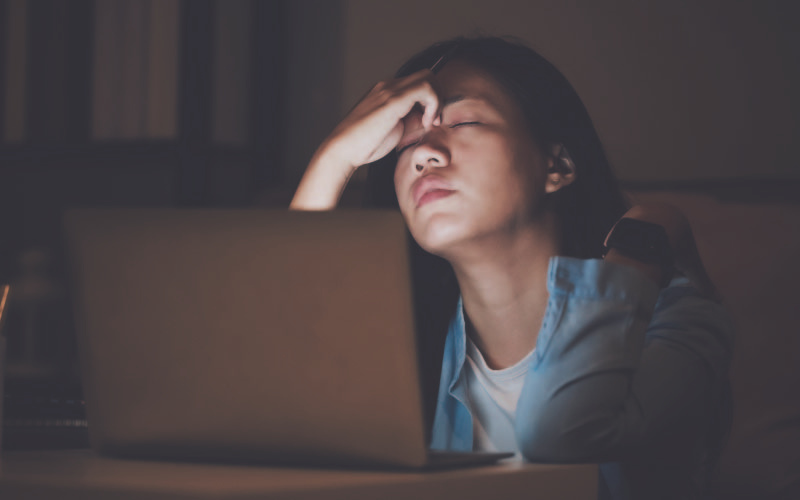 Student struggling in the dark in front of her laptop