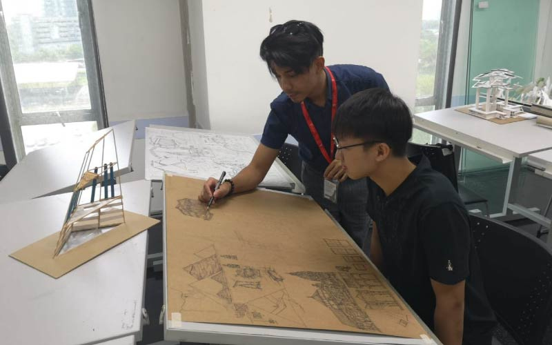 Mr. Raja Imran guiding his interior design student by showing him how it's done.