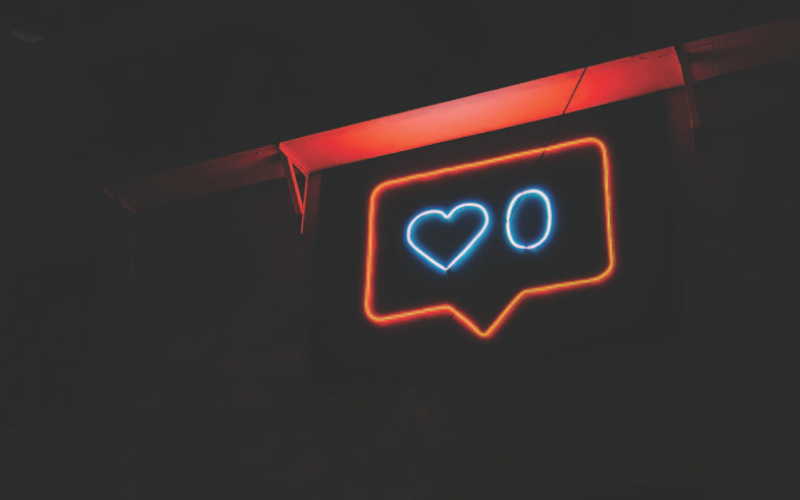 A lit, blue and red, neon sign with a heart and 0.