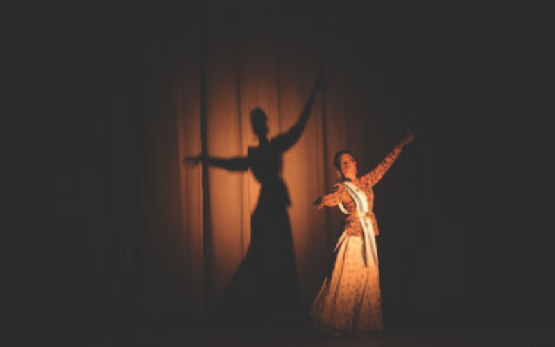 A girl performing solo on a theater stage.