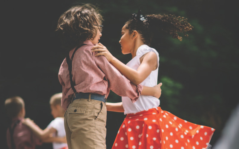 Two young children dancing together on stage