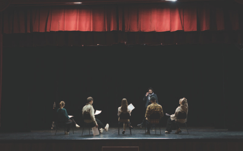 A group of theater performers rehearsing on stage