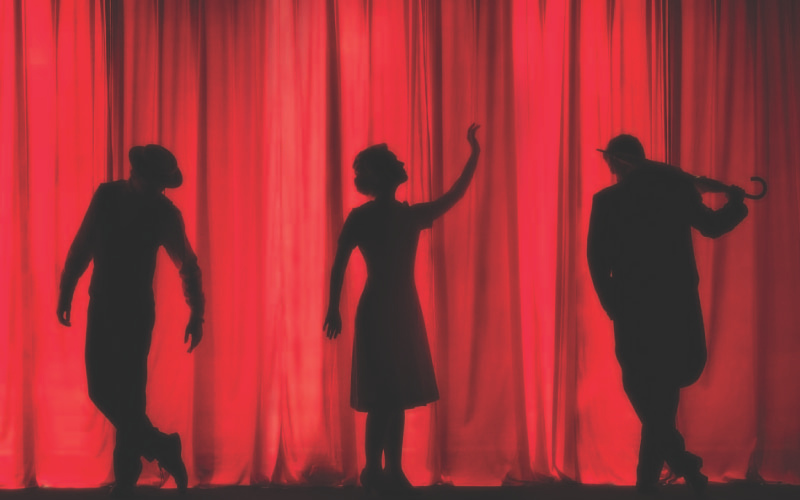 A group of performers performing together on a theater stage.