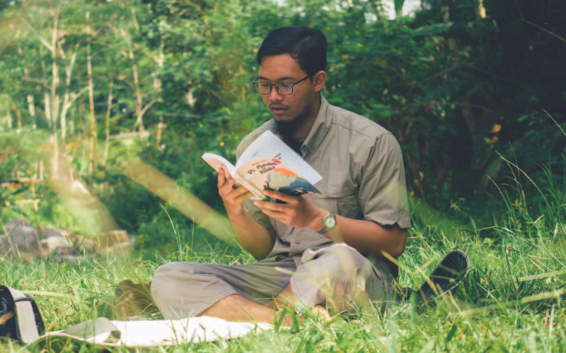 A young malay guy reading a book
