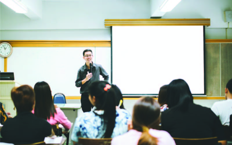 A Master's student tutoring a class of university student.