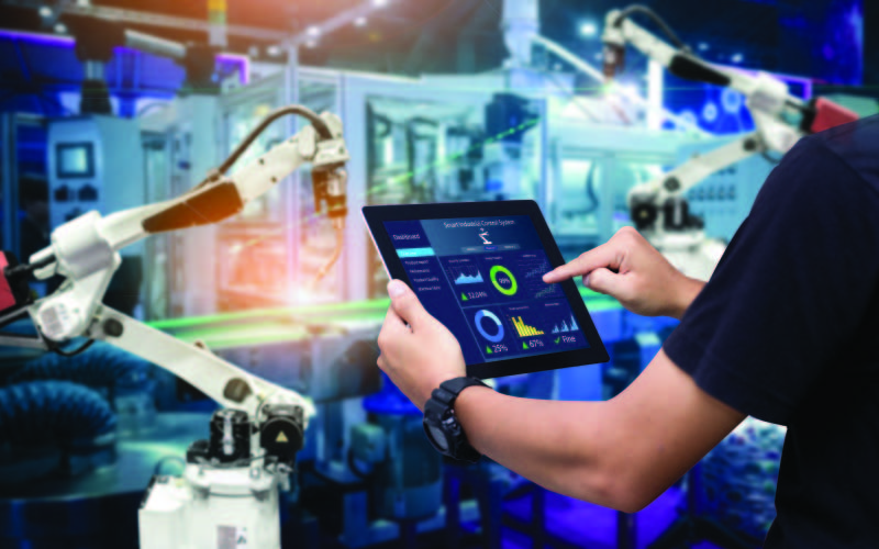 A Machine Learning Programmer analysing the data of the machine through a tablet.