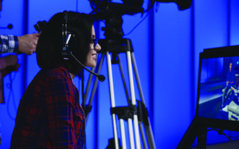 A producer looking through a screen of a live telecast