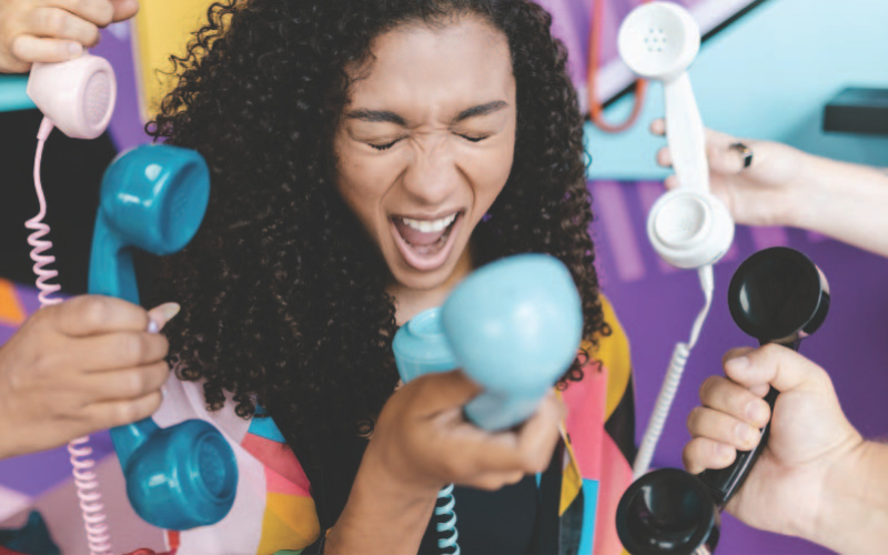 A girl screaming into a phone that's distracting her from completing her task