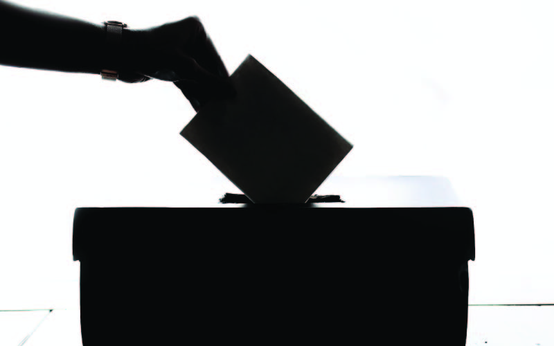 A person showing an 'UNDI18' tag on a jacket