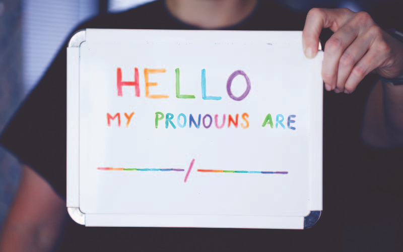 Holding up a board with pronouns