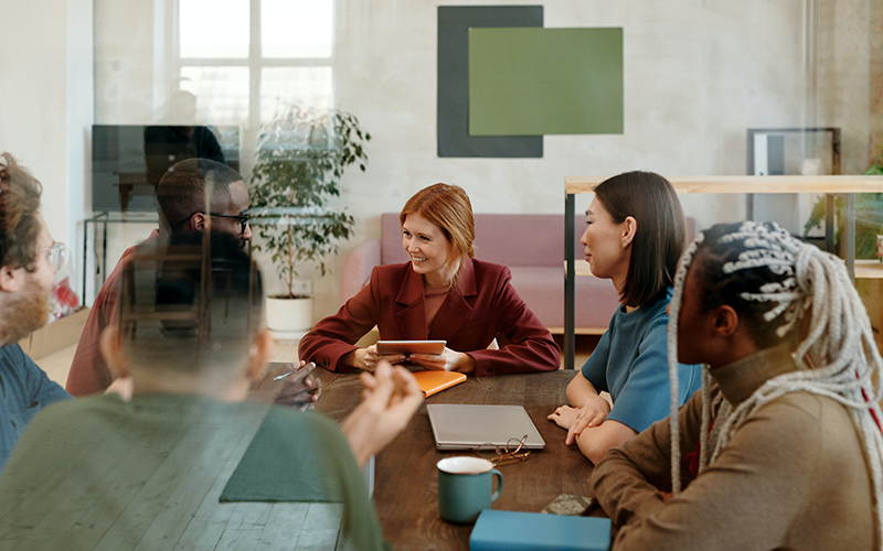 group of people sitting together in a workspace discussing