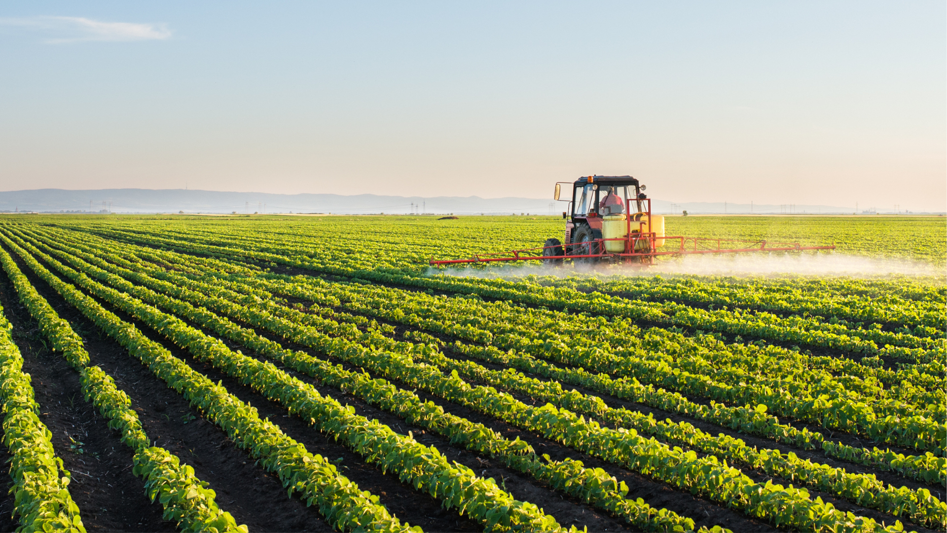 Tractor spraying herbicides on field