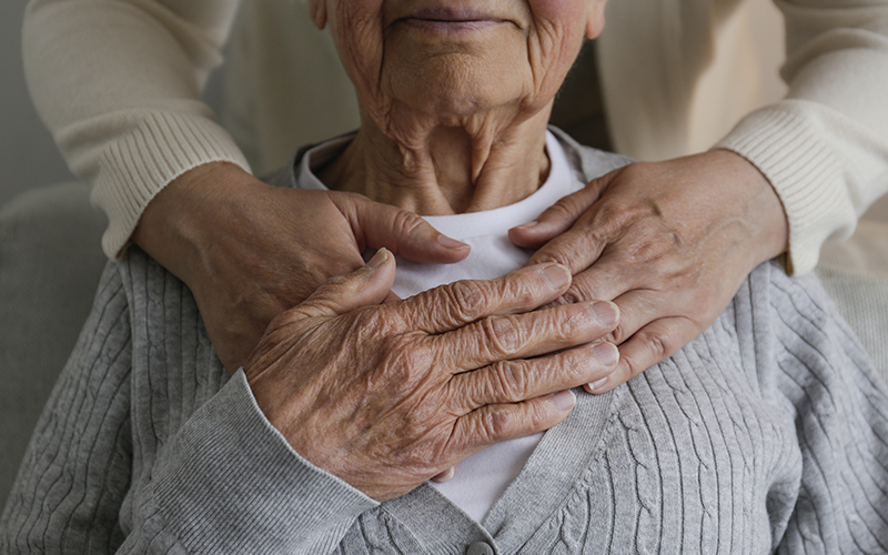 Hands over the chest of an elderly woman