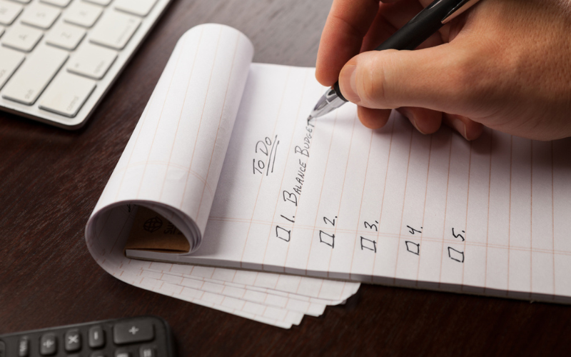 User writing notes on a notebook