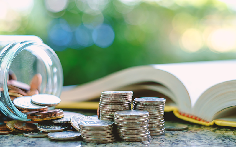 Coins stacked in front of an open book