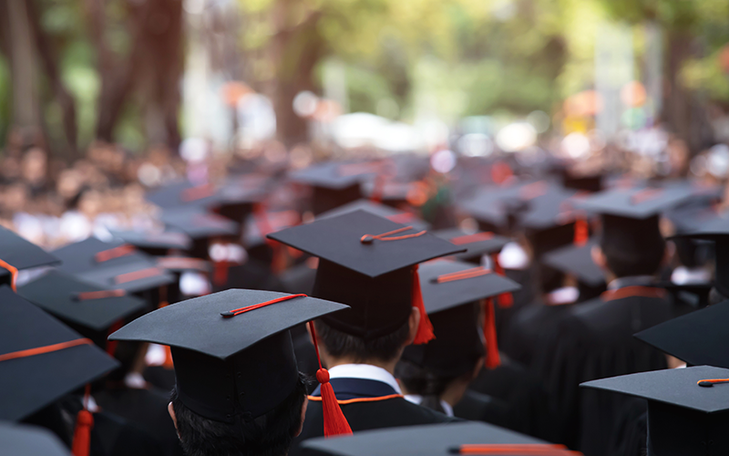 A mass of graduates wearing mortarboards