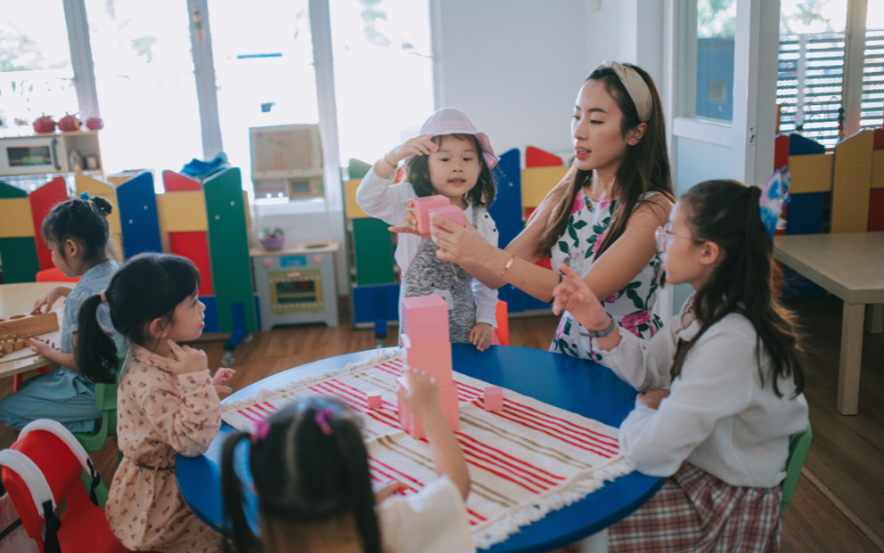 woman teaching a group of children