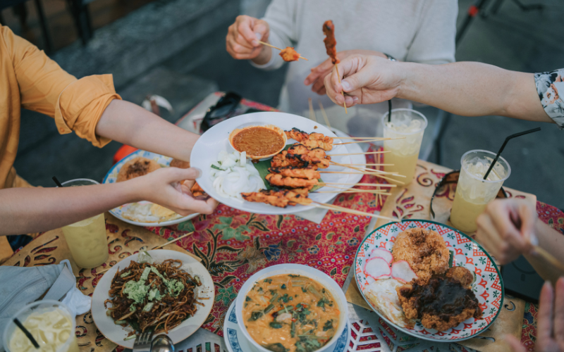 Asian tourists sharing satay