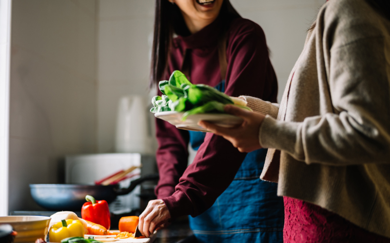 Daughter and mother preparing food in the kitchen