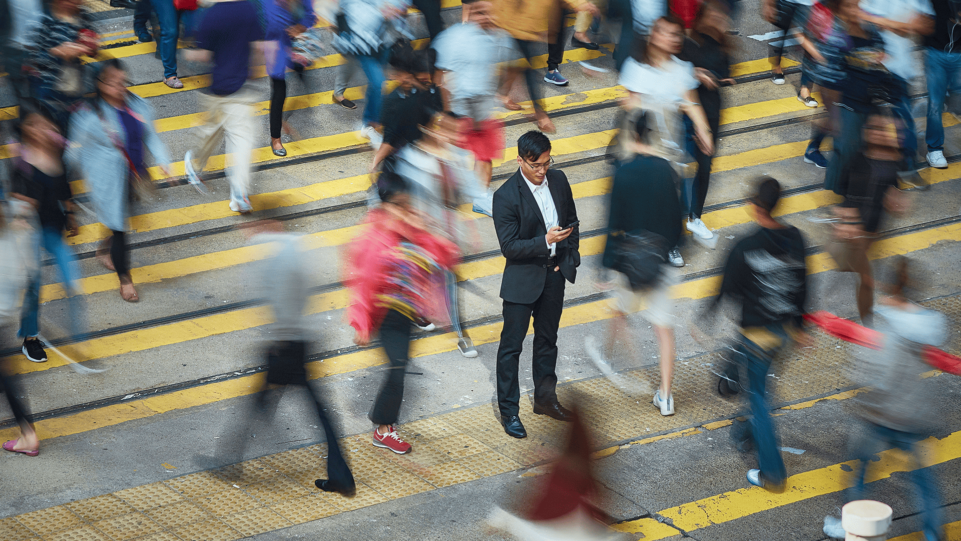 High angle view of businessman using smart phone amidst crowd