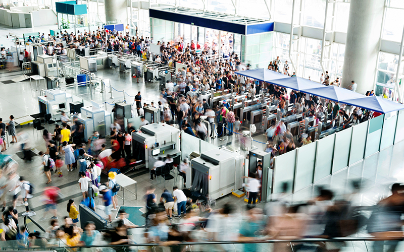 Crowd of people on railroad station lobby.