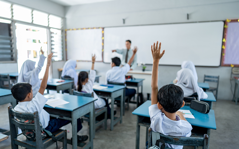 Students raising hand in the classroom