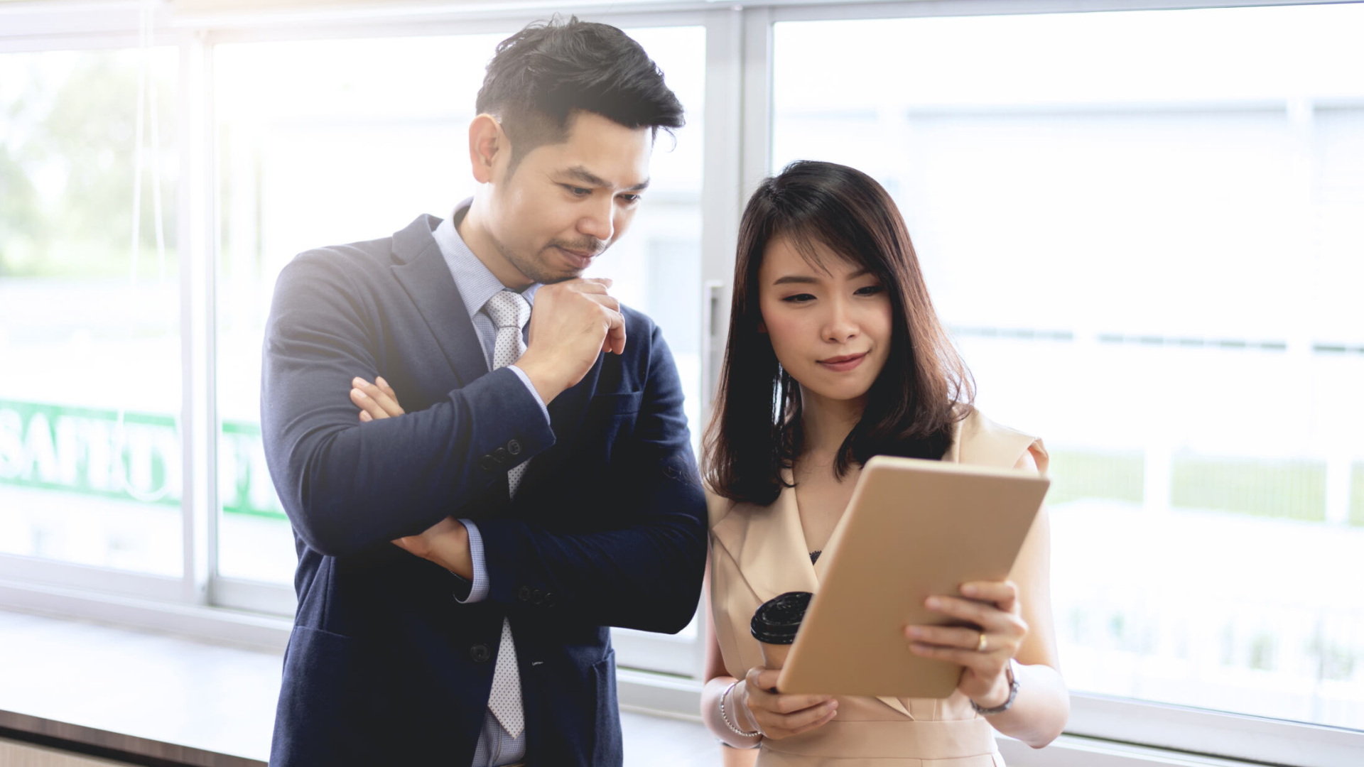 two individuals discussing over an ipad